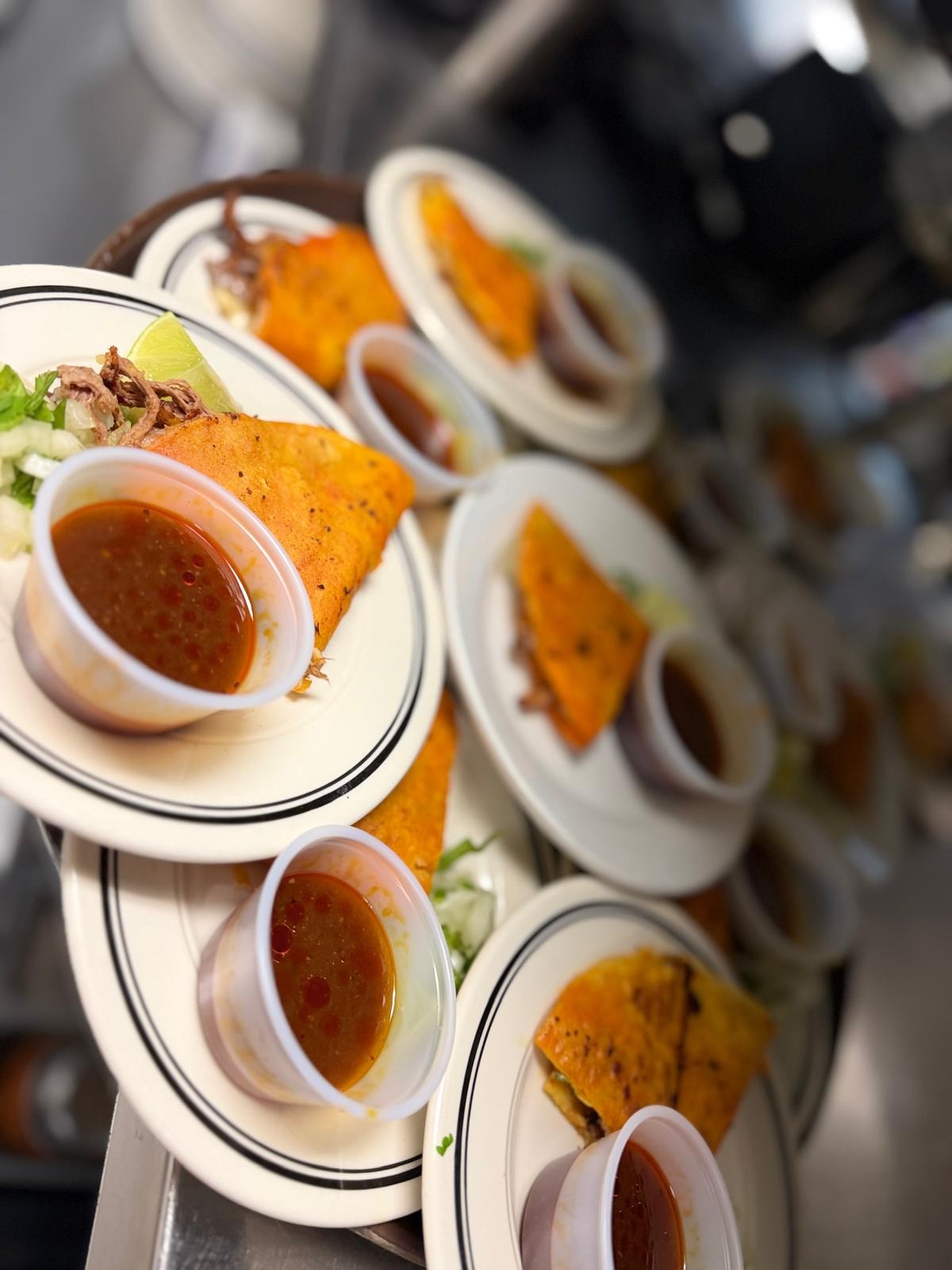Birria taco tray with consomé cups at Westrail