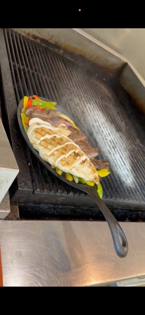 Sizzling fajitas on cast iron skillet at Westrail